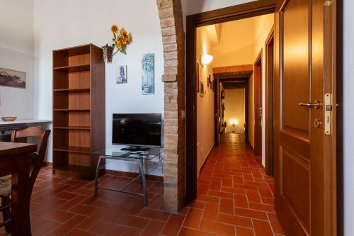 a hallway with a television and a table in a room at San Lorenzo Agriturismo in Buonconvento