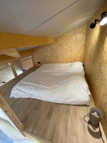 Ce lit se trouve dans une petite chambre dotée de parquet. dans l'établissement la clef des champs, à Ryes