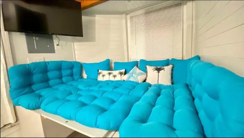 un sofá azul sentado en una sala de estar en Bolivar Tiny Home #3, en Bolivar Peninsula
