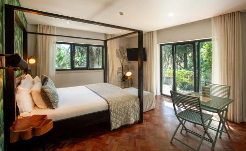 a bedroom with a bed and a table and a chair at Casa Vela Boutique House in Cascais