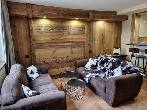 a living room with two couches and a wooden wall at Orri de Planès in Planès