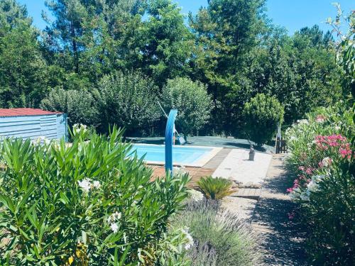 une piscine dans un jardin avec une sculpture bleue dans l'établissement Le Jas d Arcas, à Le Martinet