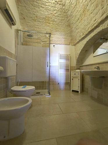 a bathroom with a shower and a toilet and a sink at Tipico Resort in Alberobello