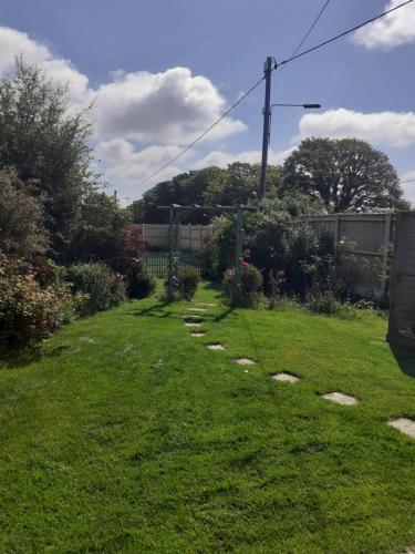 a yard with stones in the grass at Moonraker Room with a View with ensuite shower room in St Austell