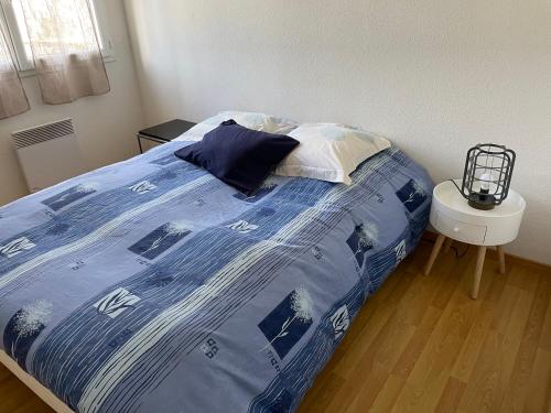 1 cama con edredón azul y blanco en un dormitorio en Rochel, en Marmande