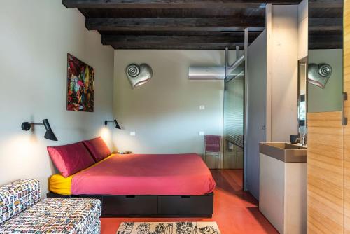 - une chambre avec un lit rouge et un canapé dans l'établissement Casa Tamì, à Viagrande