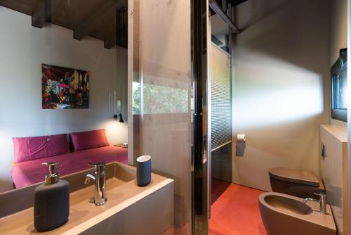 La salle de bains est pourvue d'un lavabo, de toilettes et d'un canapé. dans l'établissement Casa Tamì, à Viagrande