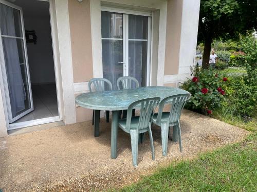 una mesa verde y sillas sentadas fuera de una casa en Rochel, en Marmande
