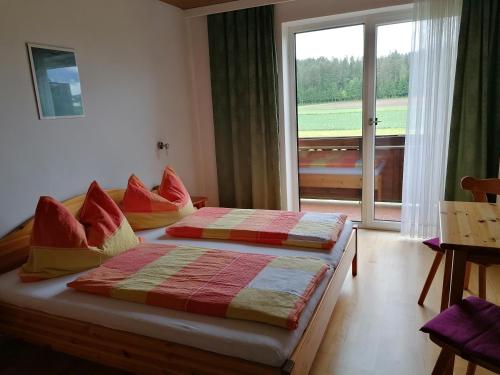 1 dormitorio con 2 camas y ventana grande en Bauernhof-Pension Puschnikhof, en Unternarrach