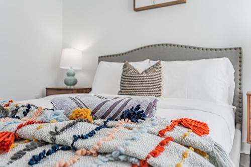 Una cama con una colorida manta de ganchillo. en Dan Leckie Apartments, en Toronto