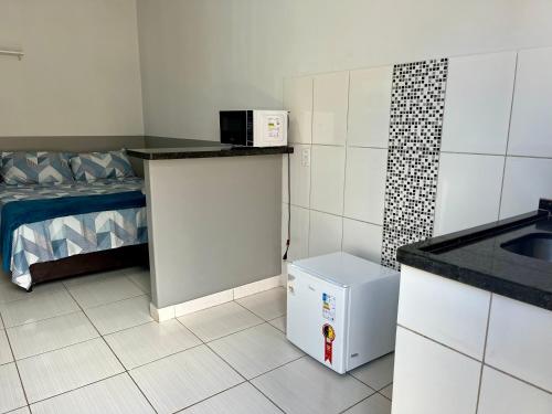 a small kitchen with a sink and a refrigerator at Casa da Vó Maria! Studio 08 in Goiânia