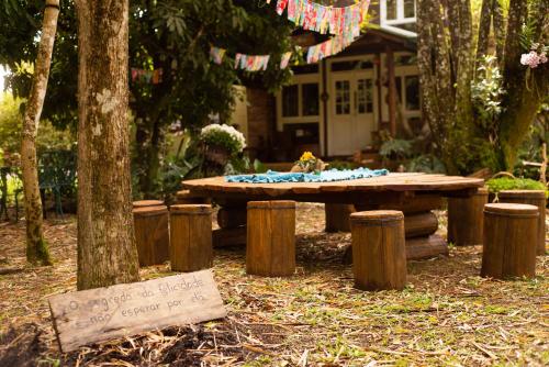- une table de pique-nique en bois devant une maison dans l'établissement Casa colonial aconchegante compartilhada, à Três Coroas