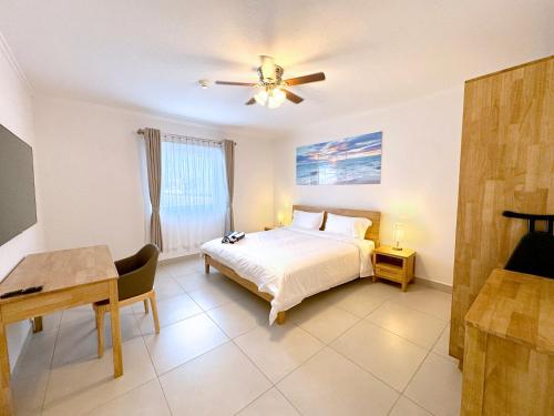 a bedroom with a bed and a ceiling fan at Bon Bini Suites in Oranjestad
