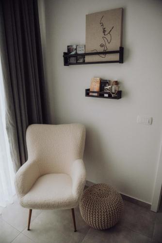 a white chair and a ottoman in a room at Studio apartment G13 in Ðakovo