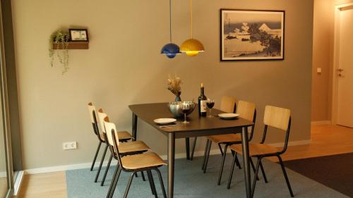 a dining room with a table with chairs and wine bottles at bluestar apartments am Storkower See inkl Badesteg und Gartensauna in Hubertushöhe