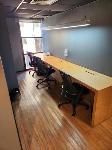 um cubículo de escritório com uma mesa e cadeiras de madeira em AlphaStay - Adágio em Barueri