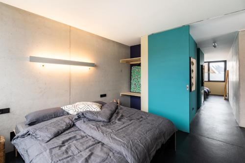 ein Schlafzimmer mit einem Bett und einer blauen Wand in der Unterkunft FRIZ Art in Gundelfingen