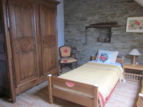 um quarto com uma cama, um armário e uma cadeira em Chambres au calme en Ardenne em Fauvillers
