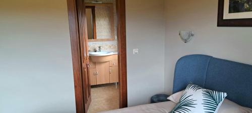 Cette chambre dispose d'un canapé bleu et d'un lavabo. dans l'établissement La Bergerie del Uncal, à Arriondas
