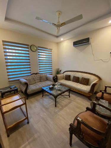 uma sala de estar com um sofá e uma mesa em Private room em Islamabad