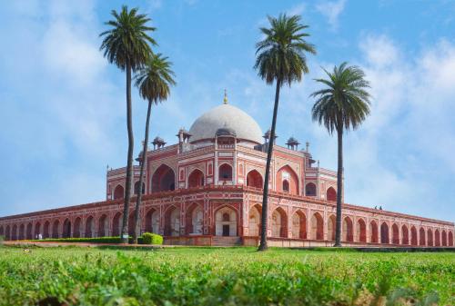 a large building with palm trees in front of it at Hotel Maharaja Inn By The Premium Villa in New Delhi