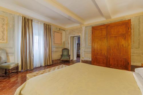 a bedroom with a large bed and a wooden cabinet at Hotel Villa Sermolli in Borgo a Buggiano