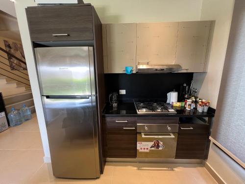 a small kitchen with a stainless steel refrigerator at Azha ain sokhna Luxury vacation villa - families only in Ain Sokhna