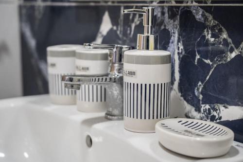 a bathroom sink with four soap dispensers on it at Stylish Studio à Ain Sebaa in Casablanca