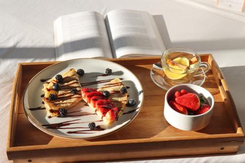 a tray with a plate of food and a book at Rado Hotel - Quintanas in Trujillo