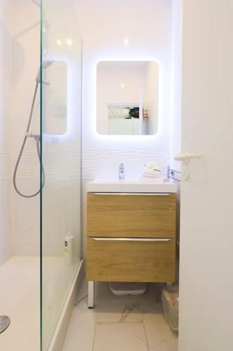 une salle de bain avec un lavabo et une douche en verre dans l'établissement 2 Pièces Vue Mer Panoramique à 5 min des plages, à Villeneuve-Loubet