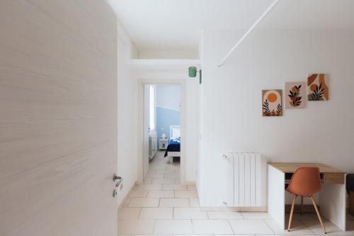 pasillo blanco con mesa y silla en Appartamento A due passi, en Imola