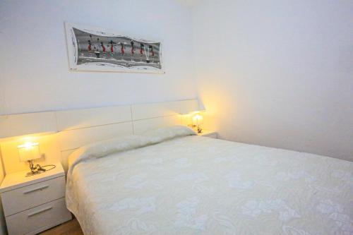 坎布里爾斯的住宿－Olimpic - ONLY FAMILIES，卧室配有白色的床和2个床头柜