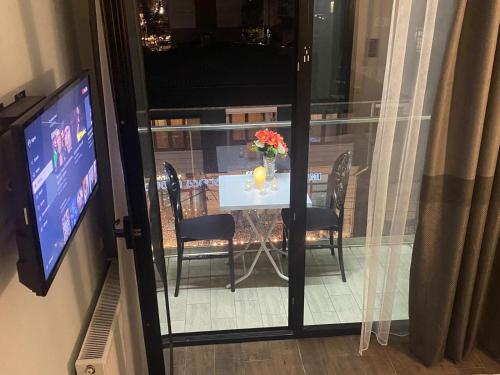 a table with a vase of flowers and a television at BATUM Hotel in Batumi