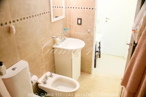 a small bathroom with a toilet and a sink at Departamento GAMA 111. in Las Varillas