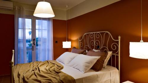 ein Schlafzimmer mit einem Bett und zwei Leuchten in der Unterkunft Kamara Apartments Marmari in Marmari