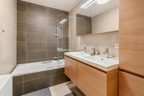 La salle de bains est pourvue d'un lavabo, d'une baignoire et d'une douche. dans l'établissement Resedentie Prado, à Ostende