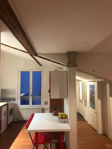 - une cuisine avec une table blanche, des chaises et des fenêtres dans l'établissement Appartement parisien, à Paris