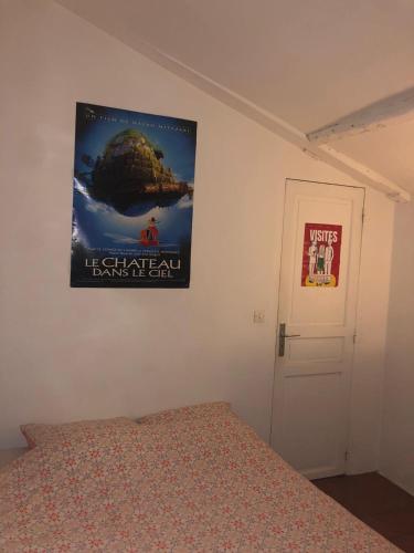 - une affiche sur un mur au-dessus d'un lit dans une chambre dans l'établissement Appartement parisien, à Paris
