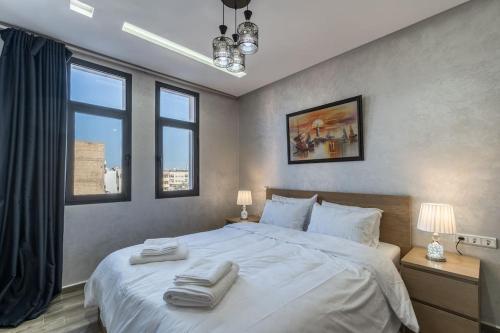 1 dormitorio con 1 cama blanca grande y 2 toallas en Chic Apartment Cosy Stay, en Casablanca