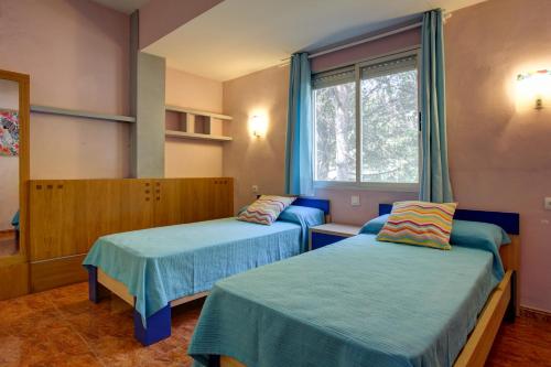 Playa de GandiaにあるDucal center complejoのベッド2台と窓が備わる客室です。