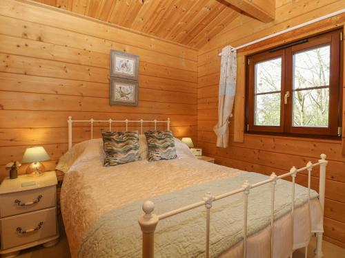 的住宿－Heron Lodge，小木屋内一间卧室,配有一张床