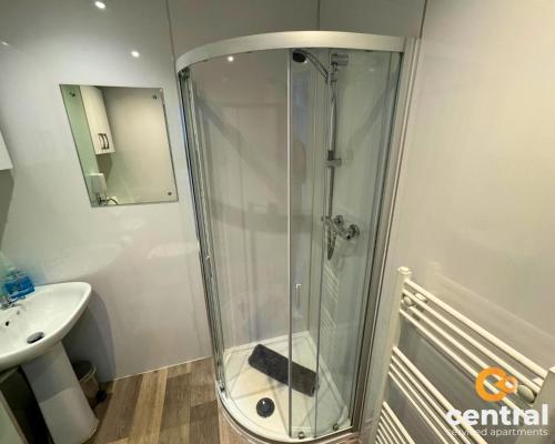 y baño con ducha de cristal y lavabo. en 2 Bedroom Apartment by Central Serviced Apartments - Ground Floor - Monthly & Weekly Bookings Welcome - FREE Street Parking - Close to Centre - 2 Double Beds - WiFi - Smart TV - Fully Equipped - Heating 24-7, en Dundee