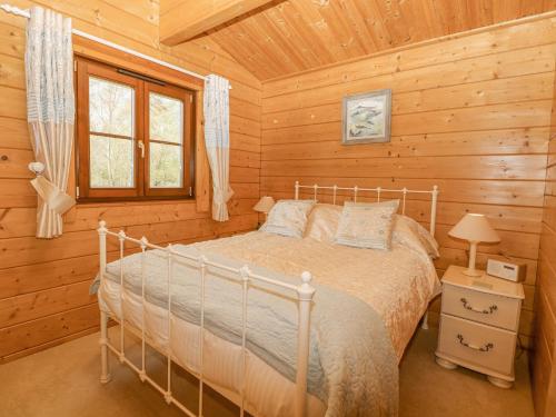 的住宿－Woodpecker Lodge，小木屋内一间卧室,配有一张床