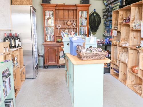a store with a refrigerator and a counter in a room at Heron Lodge in Langham