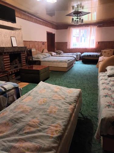um quarto com várias camas e uma lareira em Тушер em Rakhiv