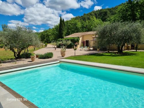 une piscine devant une maison avec des arbres dans l'établissement Escapade paisible au coeur du Luberon, à Grambois