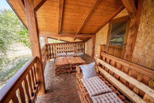 a porch of a cabin with benches and a table at Artemis in Stankovci