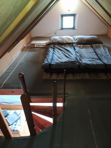 an attic room with a bed and a window at Apartmán u lesa u Adršpachu in Jívka