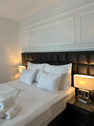 a bedroom with a bed with white pillows and two lamps at Daphne Luxe Retreat -Sea View-King size bed- in Supetar