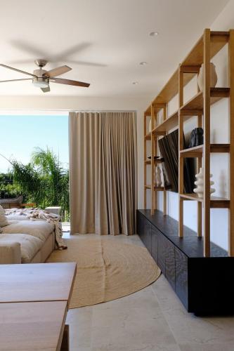 a living room with a couch and a book shelf at Pacifica by Pardela in Bucerías